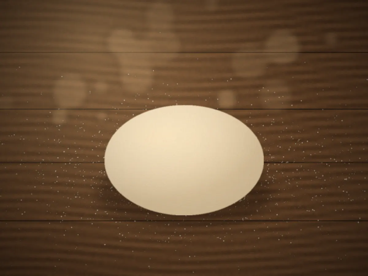 Smooth ball of rested bread dough on a lightly floured work surface